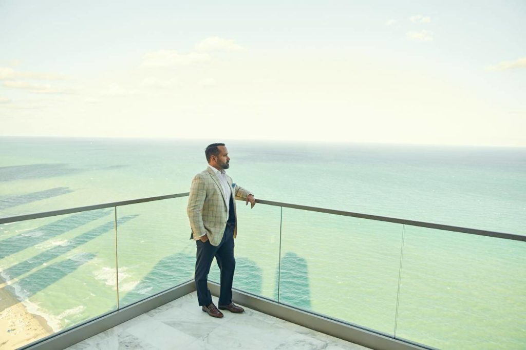 Alex Algarin, looking over the ocean from balcony.