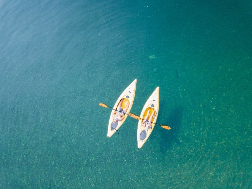 Two kayaks floating peacefully together out in the ocean